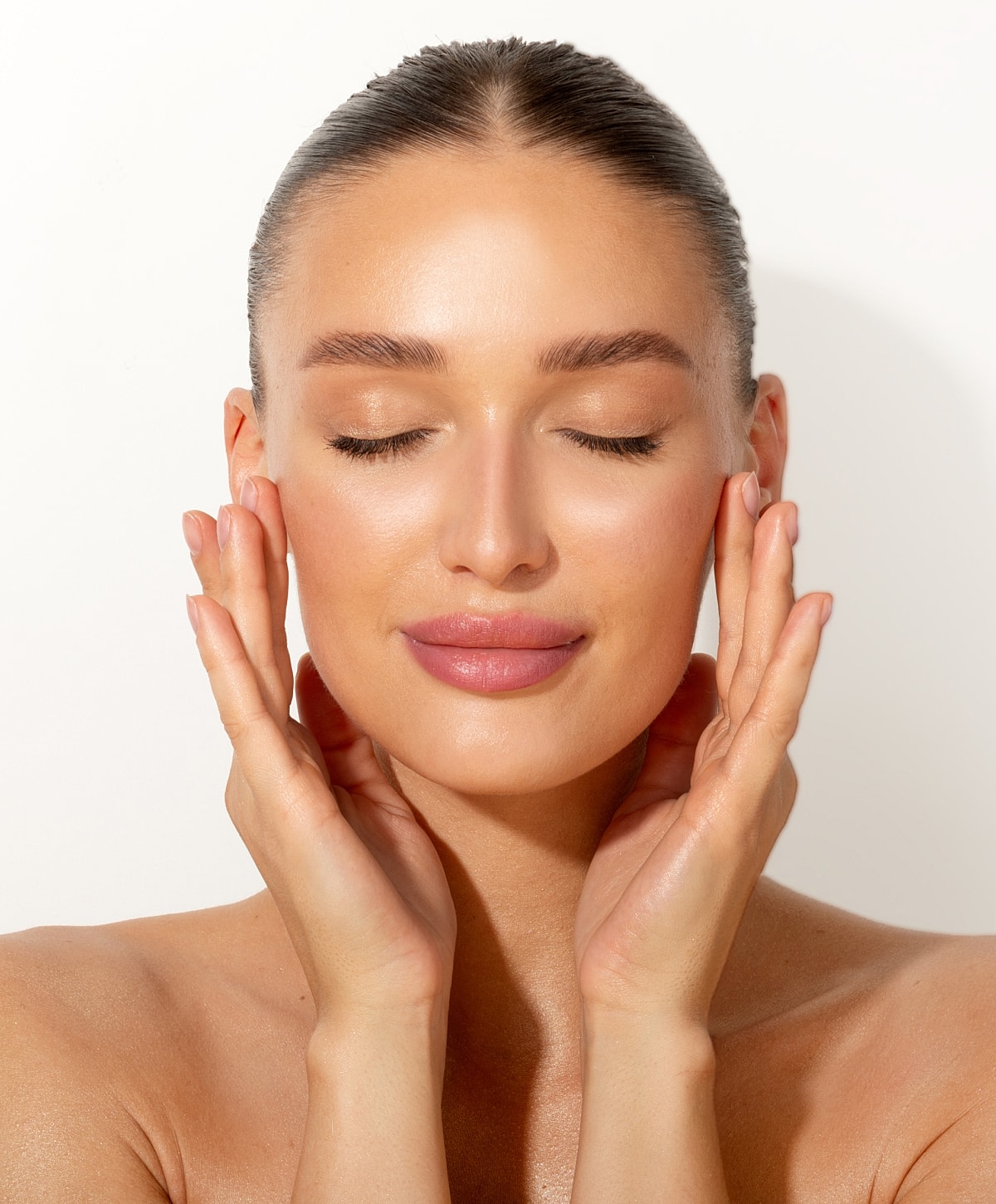 Woman with closed eyes touching her face.
