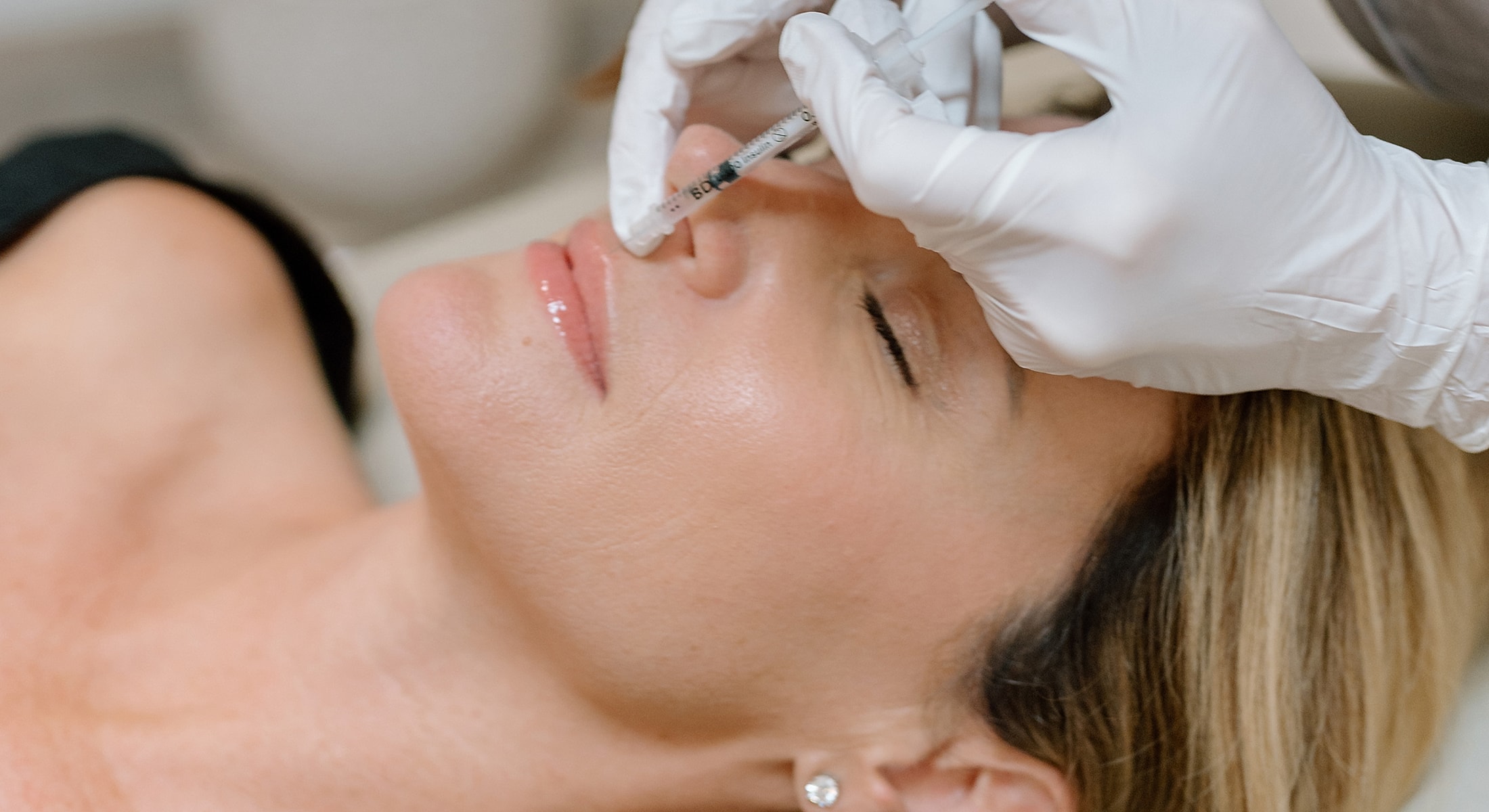 Woman receiving cosmetic injection in clinical setting.