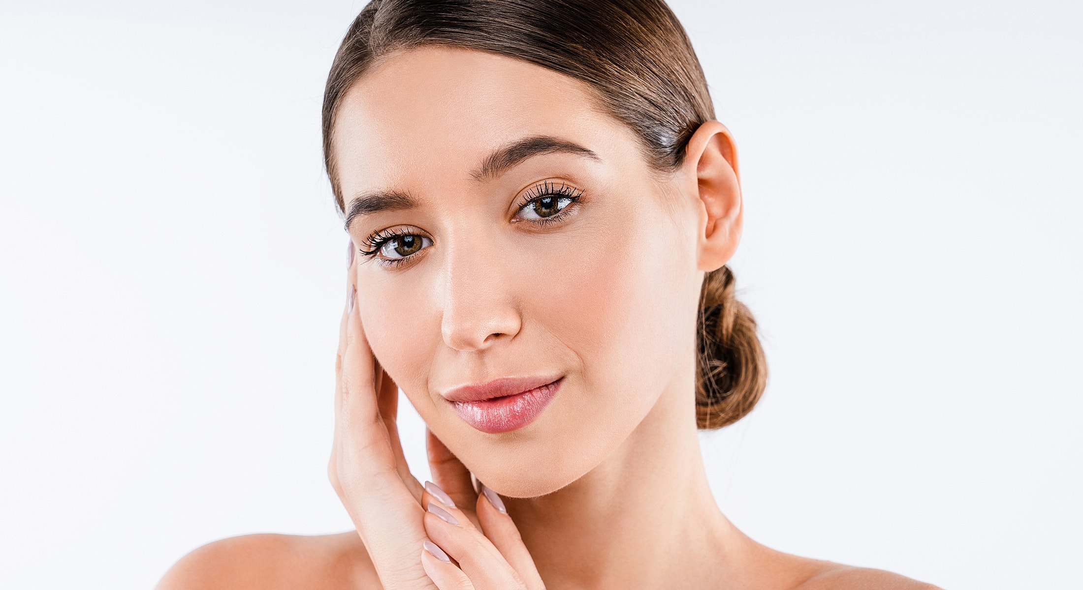 Woman gently touching her face, smiling softly.